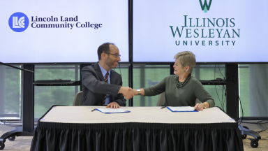 Dr. Dockter and Dr. Georgia Nugent signing the admission agreement while sitting at a table.
